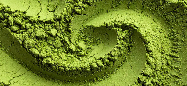 Nahaufnahme von fein gemahlenem, intensiv grünem Matchapulver mit körniger Struktur.