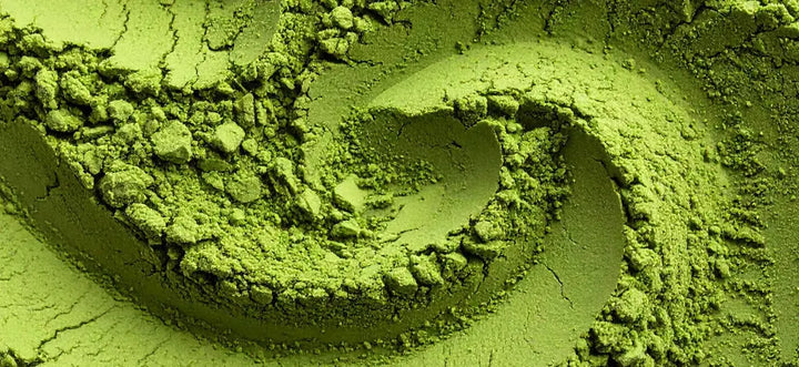 Nahaufnahme von fein gemahlenem, intensiv grünem Matchapulver mit körniger Struktur.