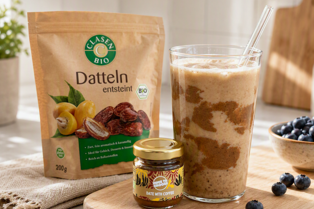 Copilot said:  Cremiger Iced-Latte im Glas mit Glasstrohhalm, frischen Blaubeeren und Bio-Dattelprodukt in heller Küchenatmosphäre.