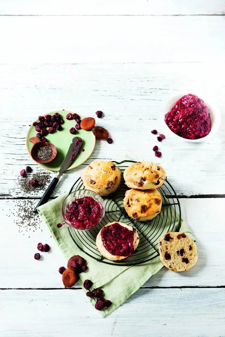 Aprikosen-Cranberry-Scones mit Chia-Marmelade, serviert auf einem Teller, daneben eine kleine Schale mit Marmelade als Beilage