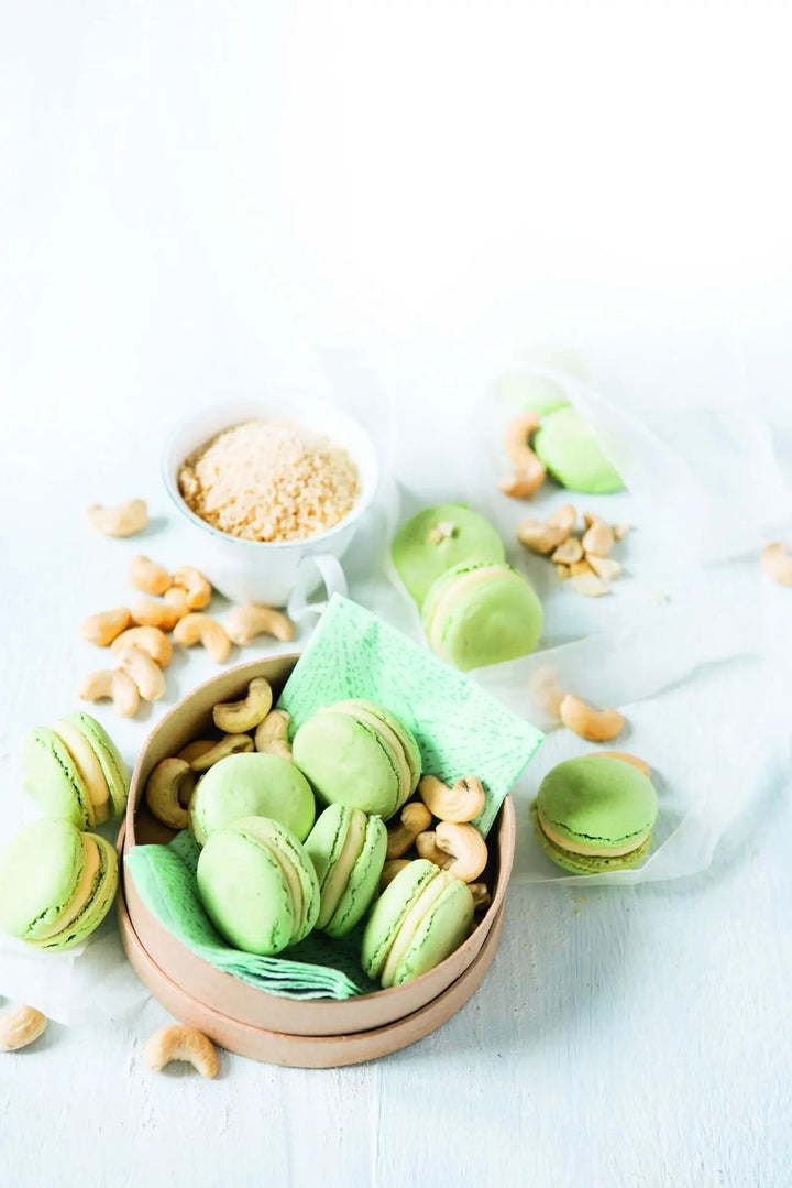 Cashew-Macarons mit cremiger Eierlikörfüllung, serviert mit Cashewkernen als Dekoration