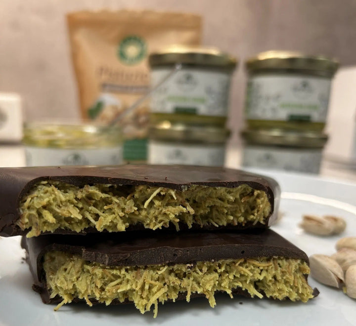 Dubai-Schokolade mit grüner Pistazien-Tahini-Füllung und knusprigem Kataifi-Kern, von Schokolade umhüllt und in zwei Hälften gebrochen – Trend-Dessert mit Crunch
