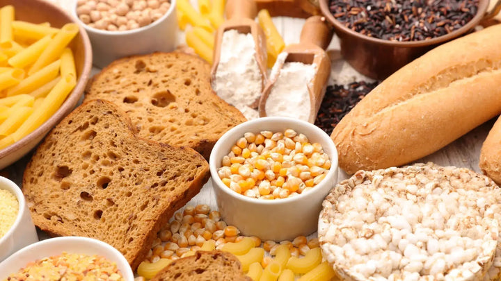 Vielfältige Auswahl an glutenfreien Lebensmitteln – darunter Obst, Gemüse, Reis, Maisprodukte, Nüsse und glutenfreies Brot, flach arrangiert