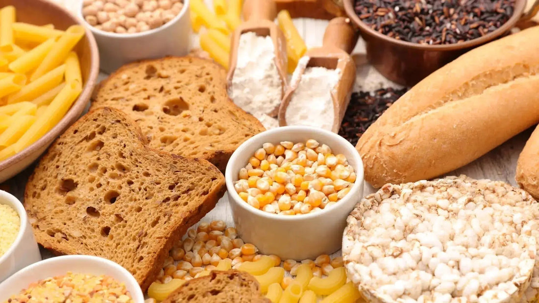 Vielfältige Auswahl an glutenfreien Lebensmitteln – darunter Obst, Gemüse, Reis, Maisprodukte, Nüsse und glutenfreies Brot, flach arrangiert