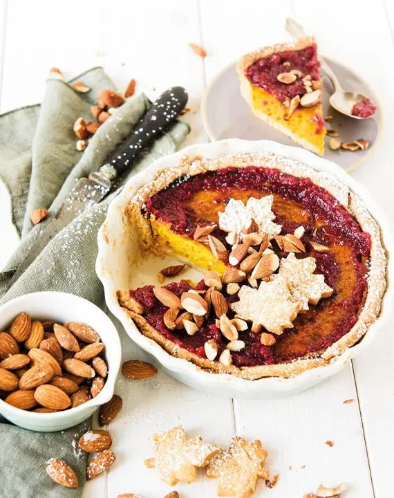 Kürbis-Pie mit Cranberry-Mandel-Topping, frisch gebacken und noch in der Backform, mit gerösteten Mandeln als Garnitur