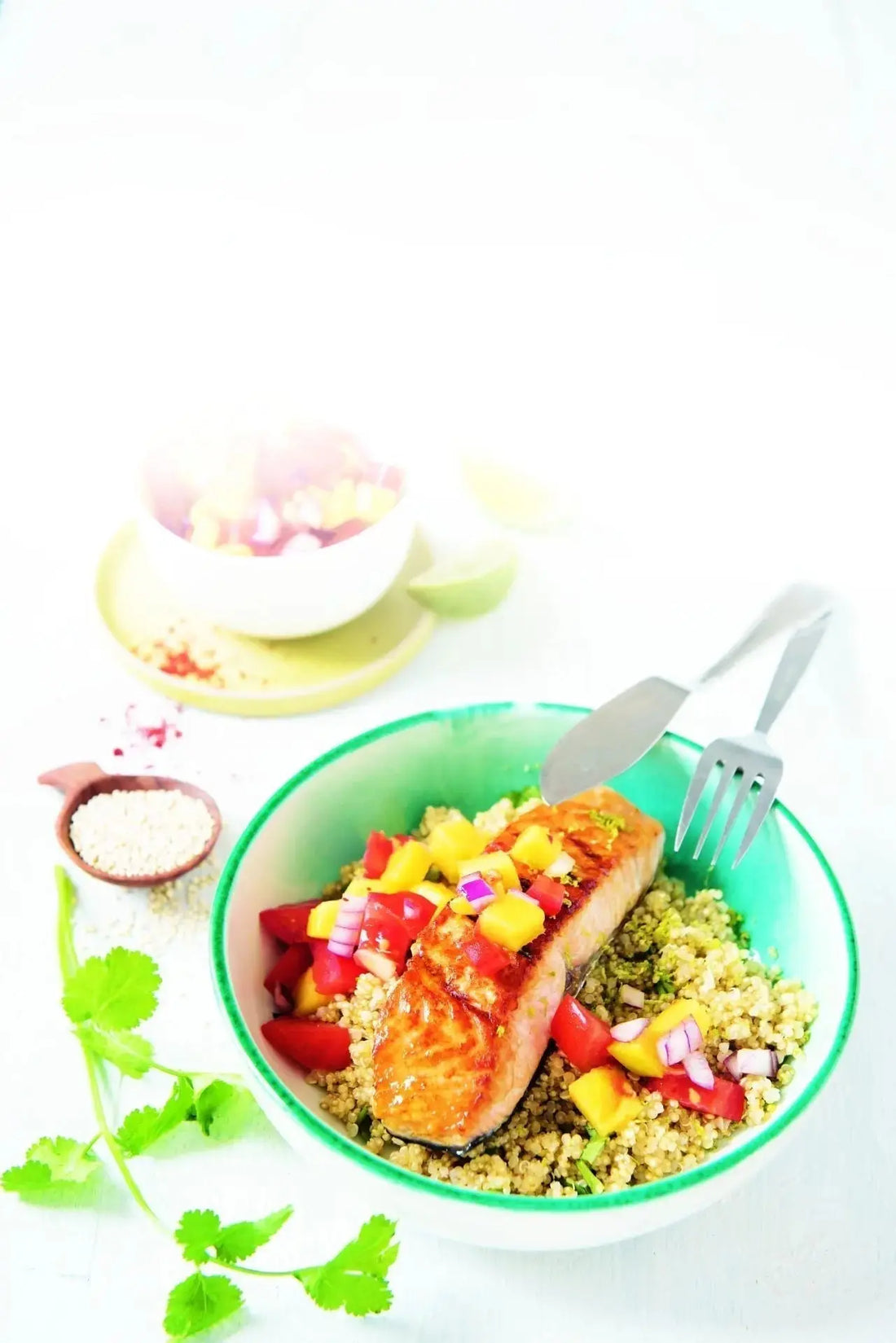 Limetten-Quinoa mit gegrilltem Lachsfilet und bunter Mango-Tomaten-Salsa, dekorativ angerichtet auf einem Teller
