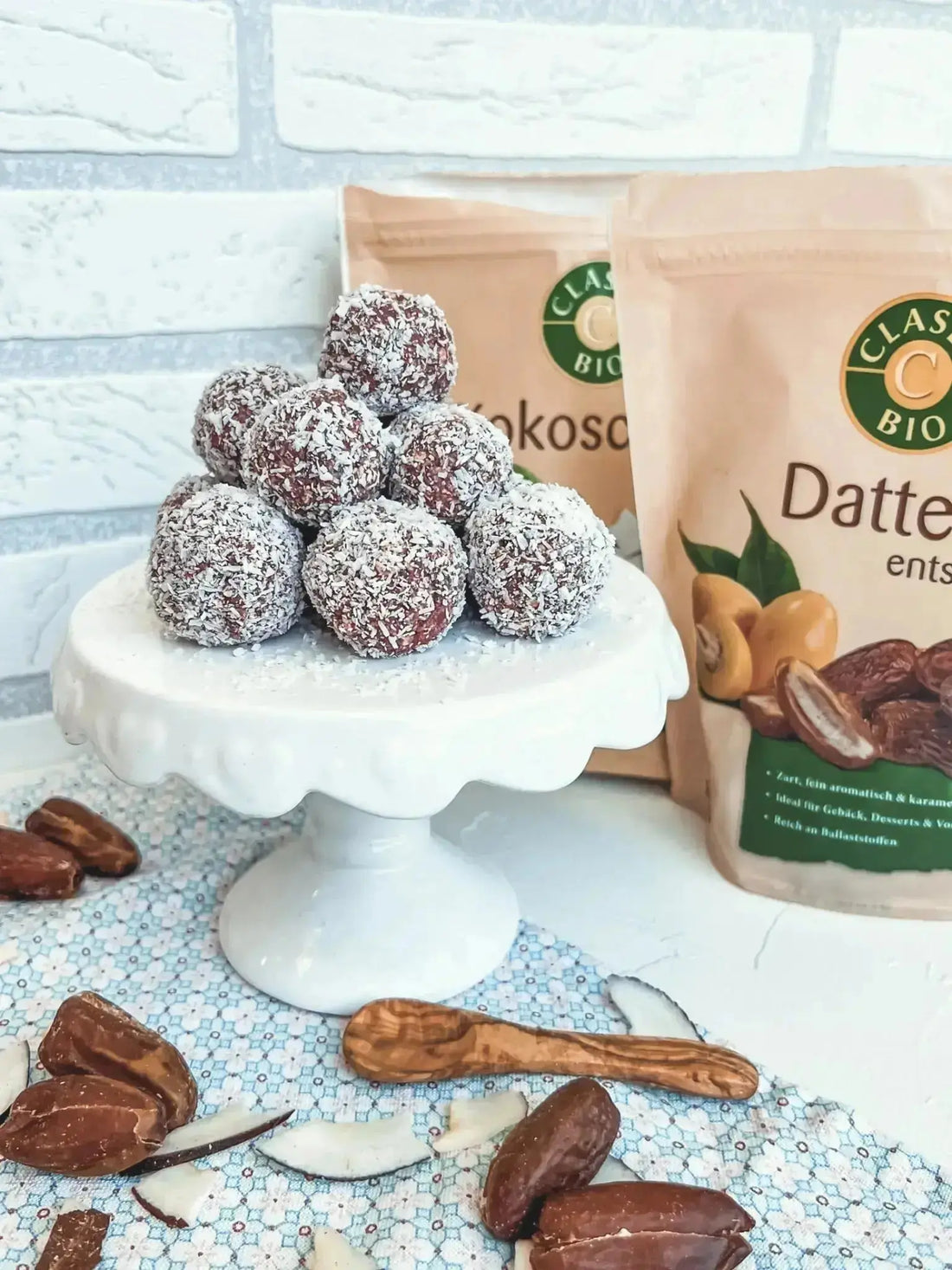Pinke Energy Balls mit Datteln und Himbeeren, dekoriert mit Datteln und Kokoschips