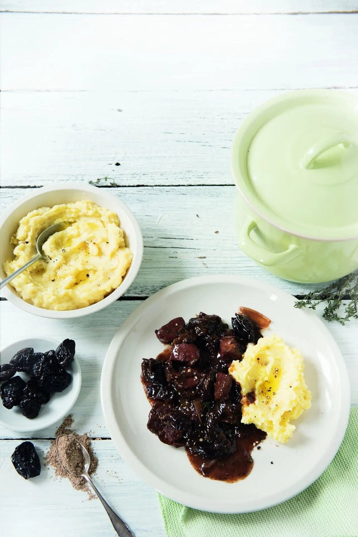Schweinefilet mit Portweinsauce und Pflaumen, in Scheiben geschnitten und dekorativ auf einem Teller angerichtet