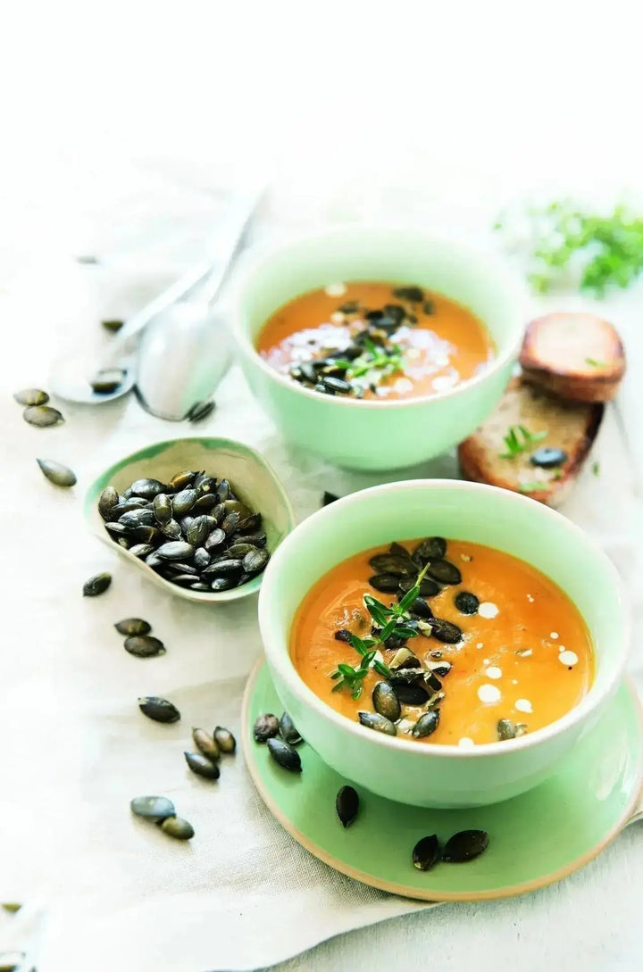 Süßkartoffelsuppe mit gerösteten Kürbiskernen, serviert in einer Schale, mit knusprigen Kernen als Topping