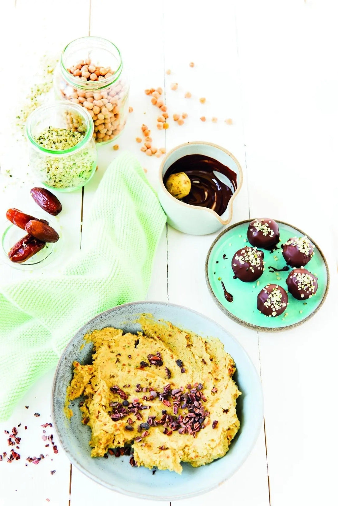 Zarte Cookie-Dough-Pralinen mit Kichererbsen und Datteln, angerichtet auf Keramiktellern, mit Datteln als Dekoration