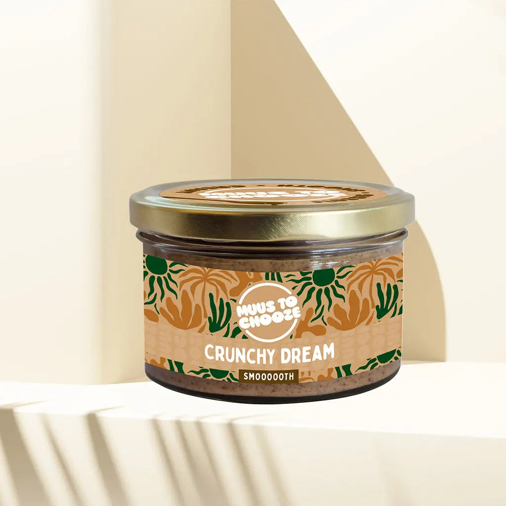 Verpackung Bio-Mandelmus Crunchy Dream 180 g von MUUS TO CHOOZE – nussig-knuspriges Mandelmus im Glas mit goldfarbenem Deckel und farbenfrohem Etikett