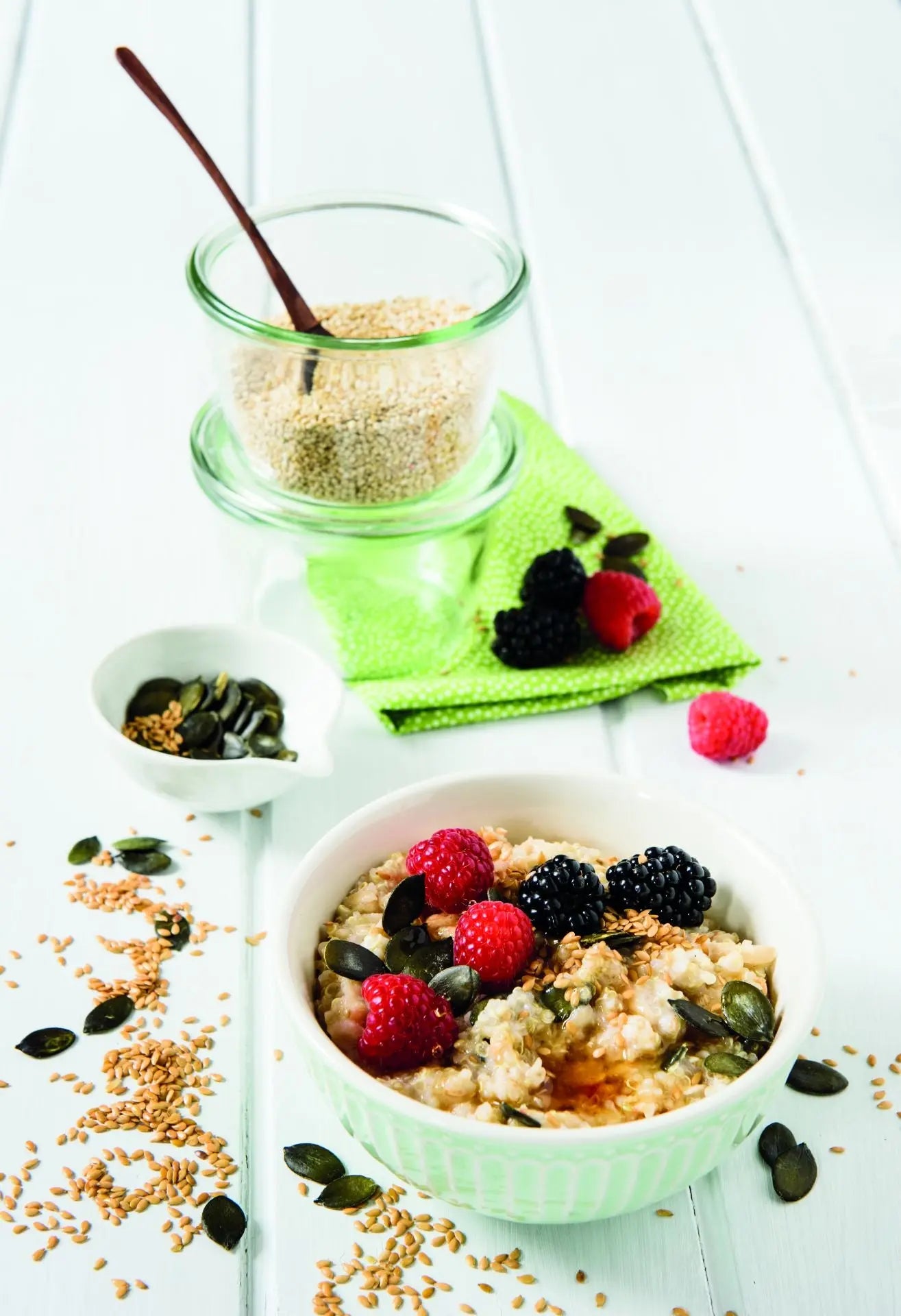 Bircher-Quinoa mit Kürbiskernen und Goldleinsamen, serviert in einer Schale mit frischem Obst.